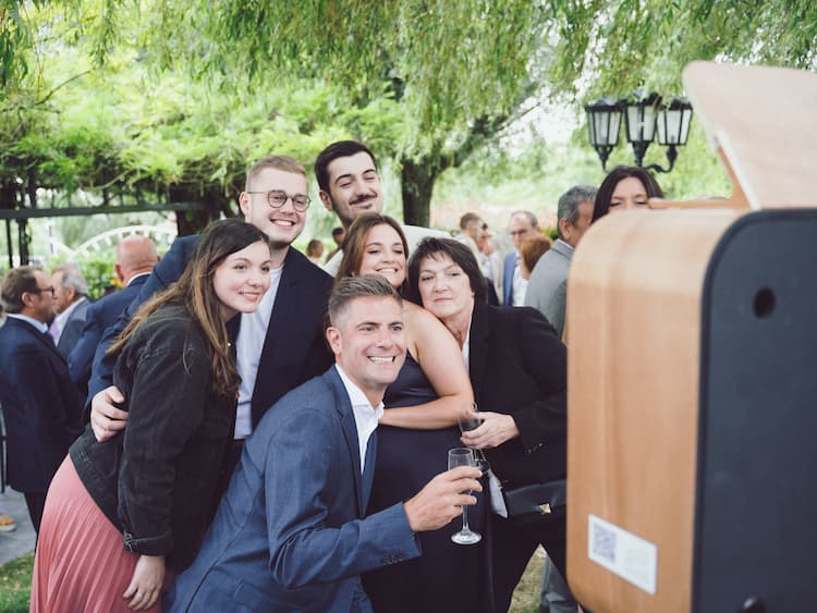 Groupe d'invités à un mariage prenant la pose devant la SILVER BOX, la borne photo réalisée par Matthieu Wandolski disponible en location à Valenciennes