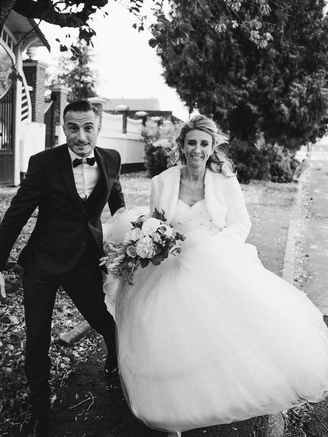 Couple de mariés marchant rapidement, photo prise dans l'action, par Matthieu Wandolski,  Photographe et Vidéaste de mariage basé dans les Hauts-de-France. Réalise des reportages de mariage de Valenciennes à Arras, Lille et Douai.