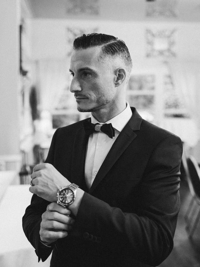 Préparatif du marié, il ajuste sa montre dans un style 007, par Matthieu Wandolski,  Photographe et Vidéaste de mariage basé dans les Hauts-de-France. Réalise des reportages de mariage de Valenciennes à Arras, Lille et Douai.